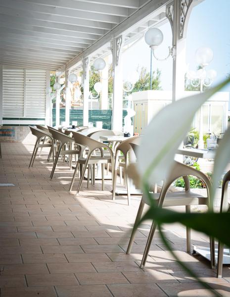Veranda with beige chairs and spherical lamps, bright and relaxing atmosphere.