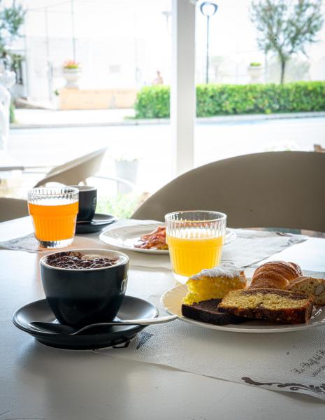 Breakfast with coffee, orange juice, and pastries on a table.