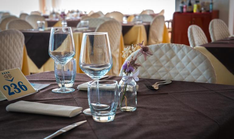 Tavolo apparecchiato in un ristorante elegante con decorazioni floreali.