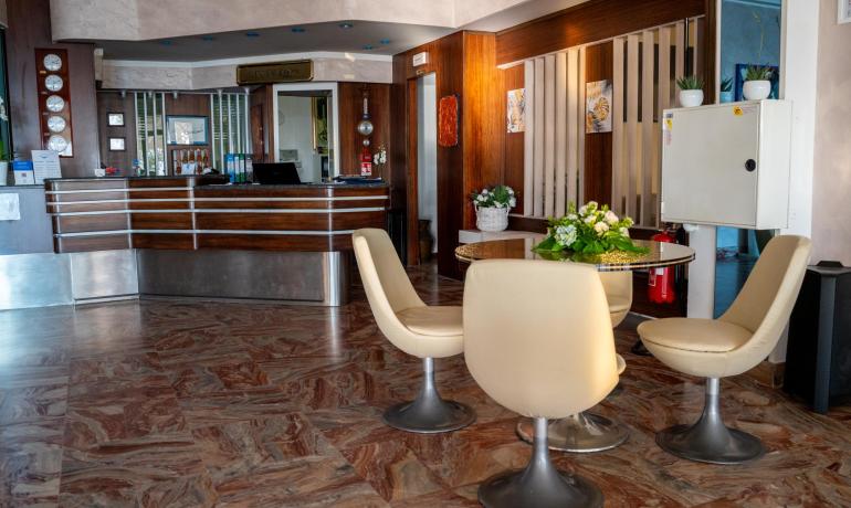 Hotelrezeption mit modernen Stühlen und Blumen auf dem Tisch.