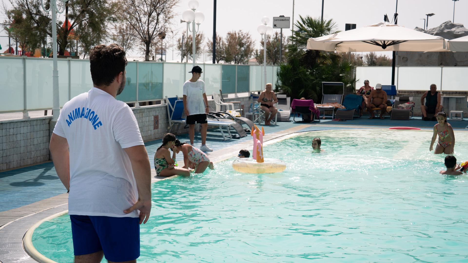 Animator watches children playing in the pool.