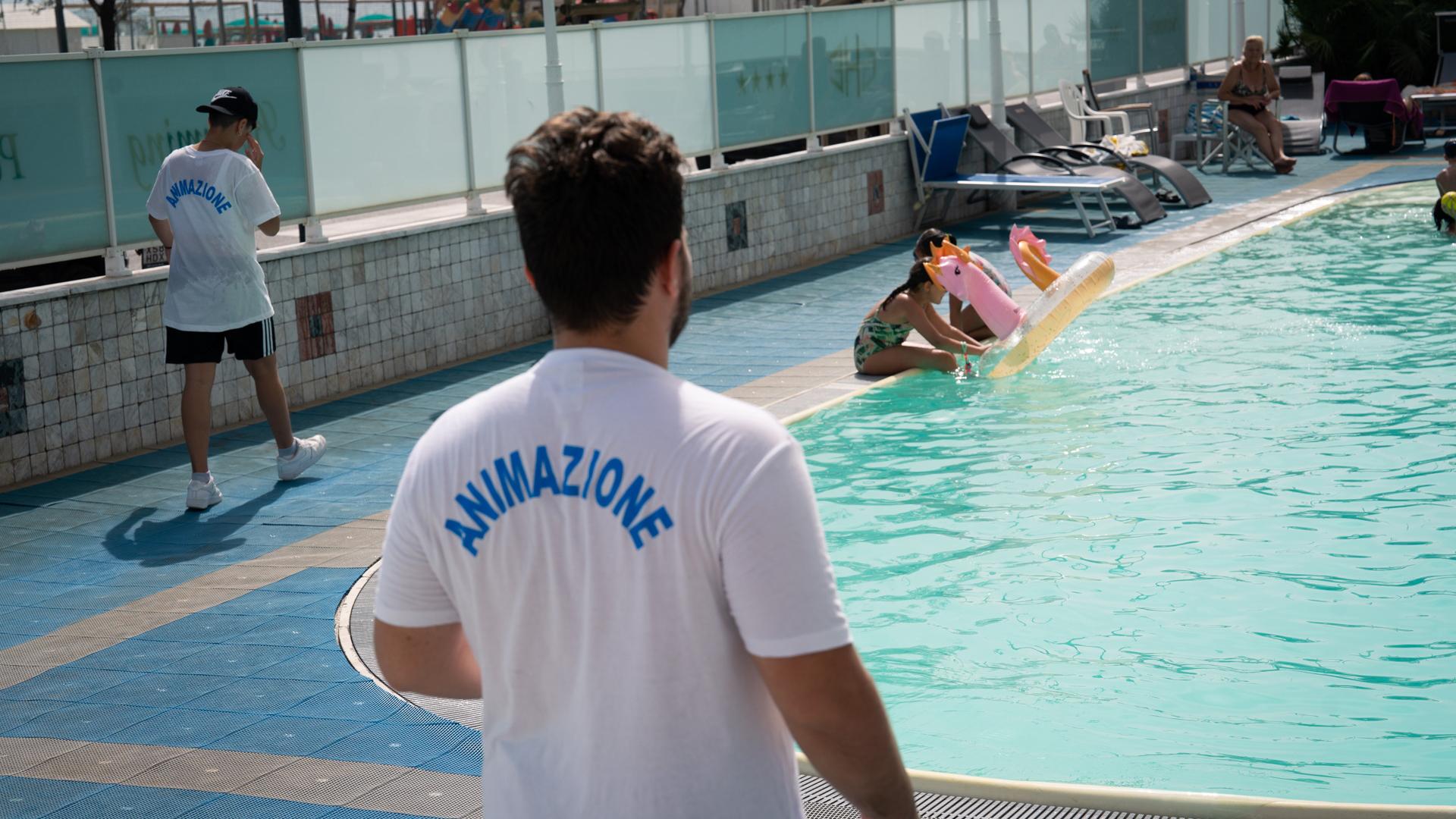 Animatori vicino alla piscina con bambini che giocano.