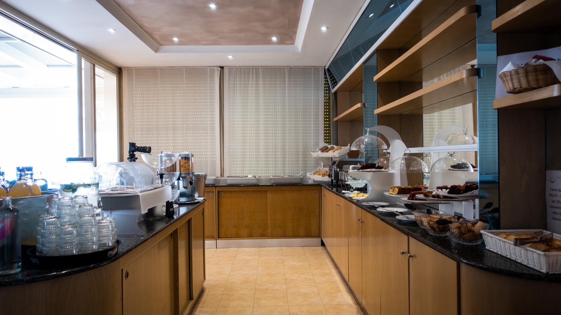 Breakfast buffet with pastries and drinks in a bright setting.
