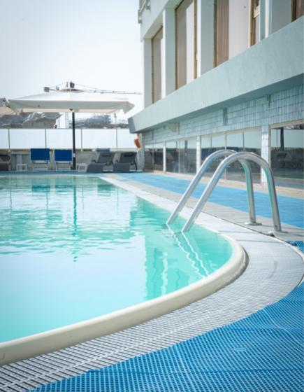 Outdoor pool with loungers and umbrellas, relaxing atmosphere.