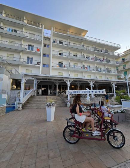 Family on a rickshaw in front of the Grand Hotel Excelsior.