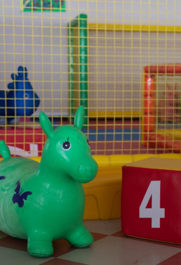 Giocattolo gonfiabile verde in area giochi con cubo rosso numero quattro.