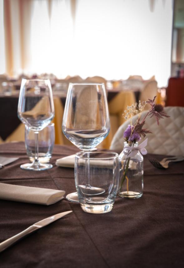 Table set with glasses and decorative flowers.