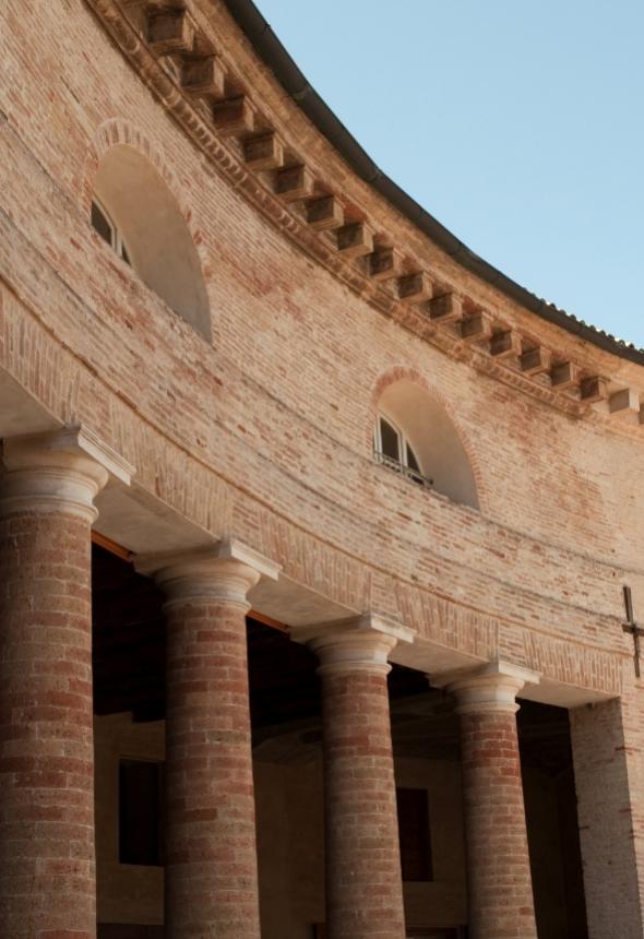 Columns and arches in a historic brick building.