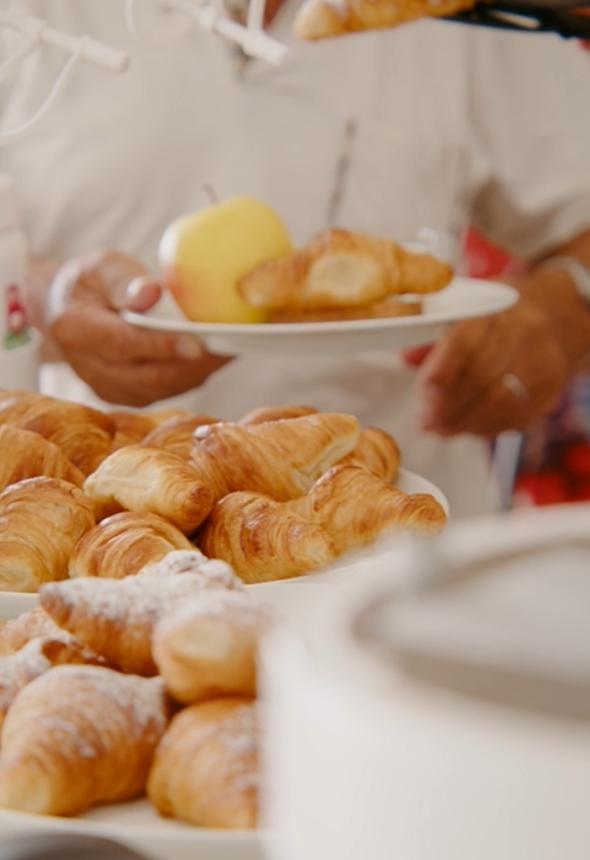 Croissants and an apple on a breakfast plate.