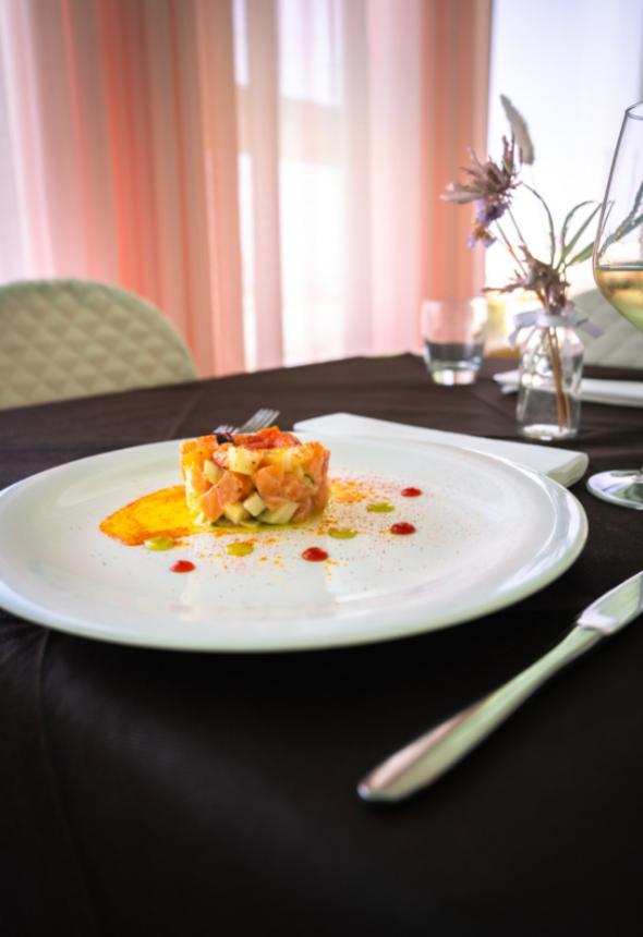 Salmon tartare with garnishes on an elegant plate.